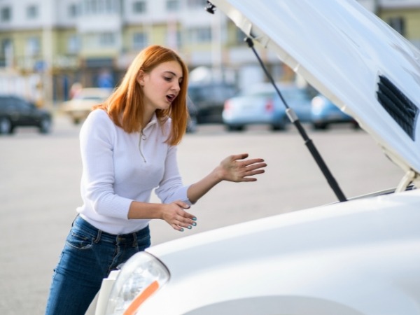 Woman Looking at a Broken Down Car